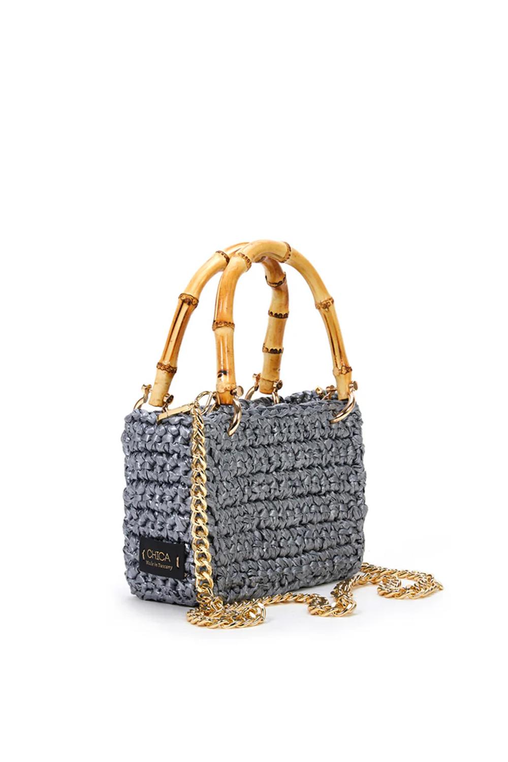 mini bag in woven raffia rectangular shape, two shiny bamboo handles and gold metal hooks with shoulder strap